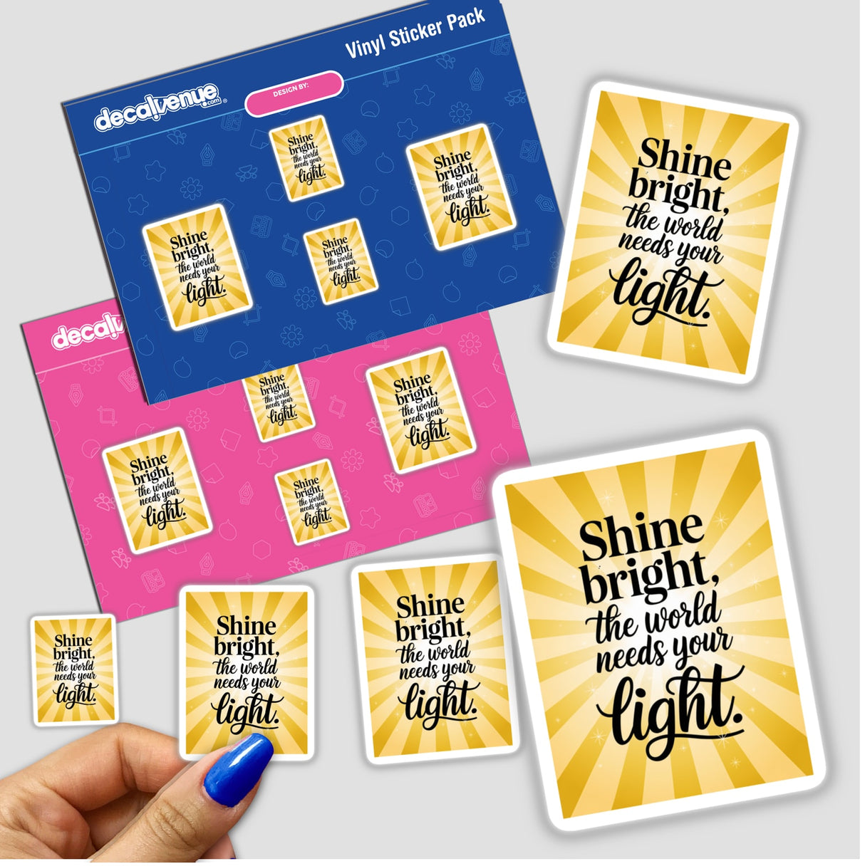 Hand holds 'Shine bright, the world needs your light' sticker pack, featuring vibrant yellow and black designs, embodying Decal Venue's unique vinyl sticker artistry.