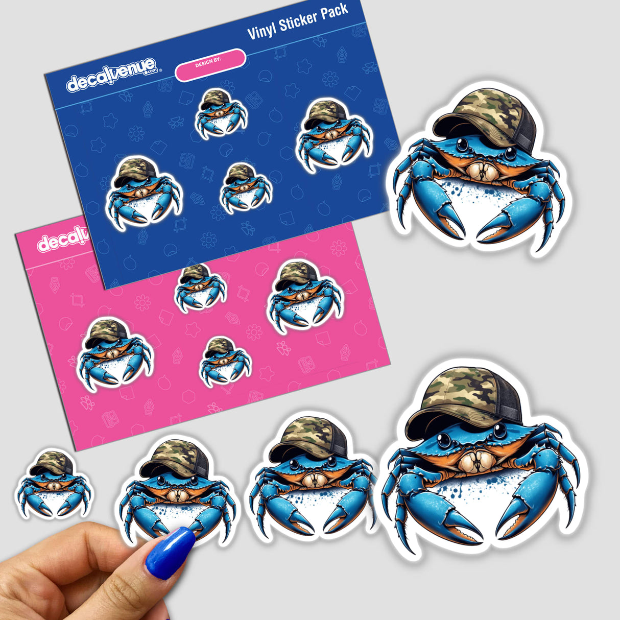 Sticker featuring a cartoon blue crab wearing a camo trucker hat, held in a hand. Part of Decal Venue's unique vinyl sticker and digital art collection.
