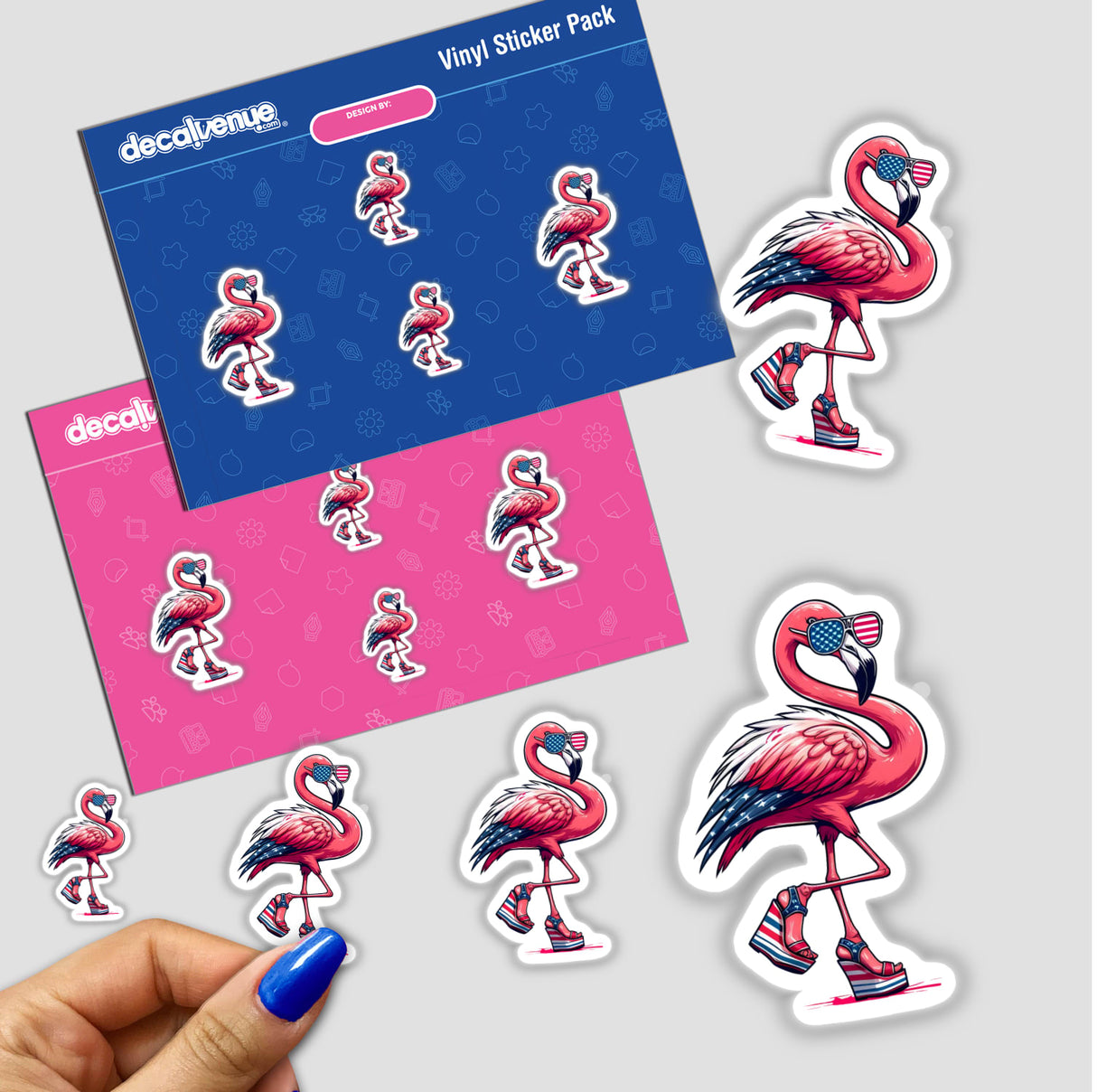 Sassy American Flamingo in Wedges vinyl sticker pack from Decal Venue, featuring stylized flamingos in star-spangled sunglasses and platform heels, with a hand peeling a small decal from a backing sheet.