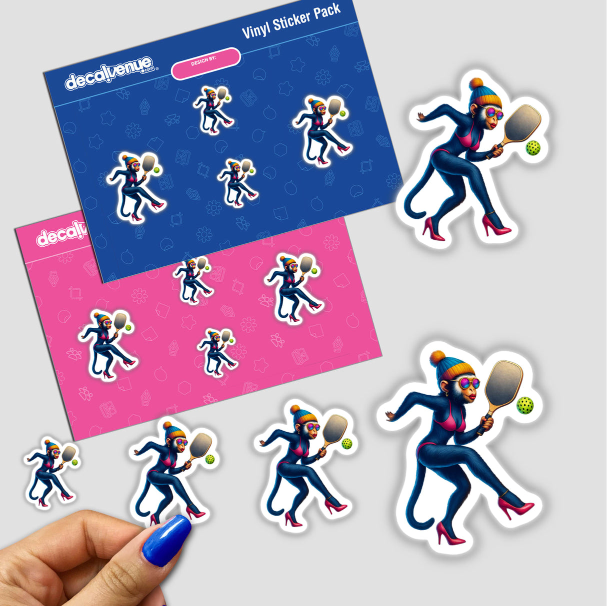 Female Monkey in Bikini and Heels Playing Pickleball vinyl sticker pack, featuring stylish monkey decals on blue and pink sheets, with a hand peeling a smaller sticker. Available as stickers or digital artwork.