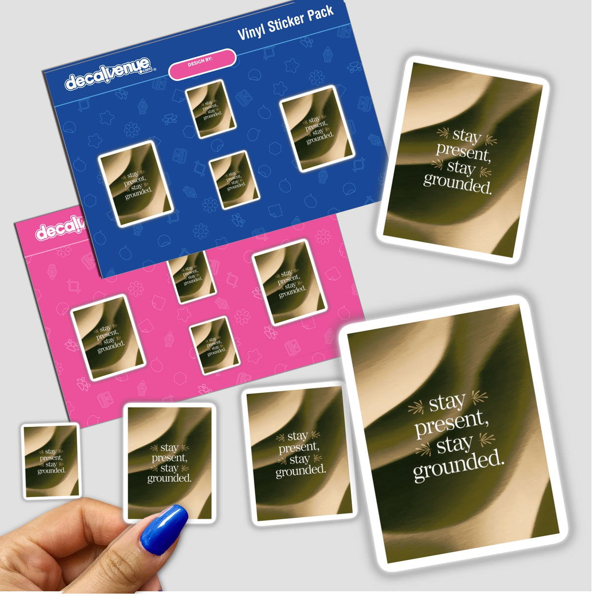 Hand holding a sticker pack featuring Stay present, stay grounded text, representing Decal Venue's unique vinyl stickers. Available as physical stickers or digital artwork.