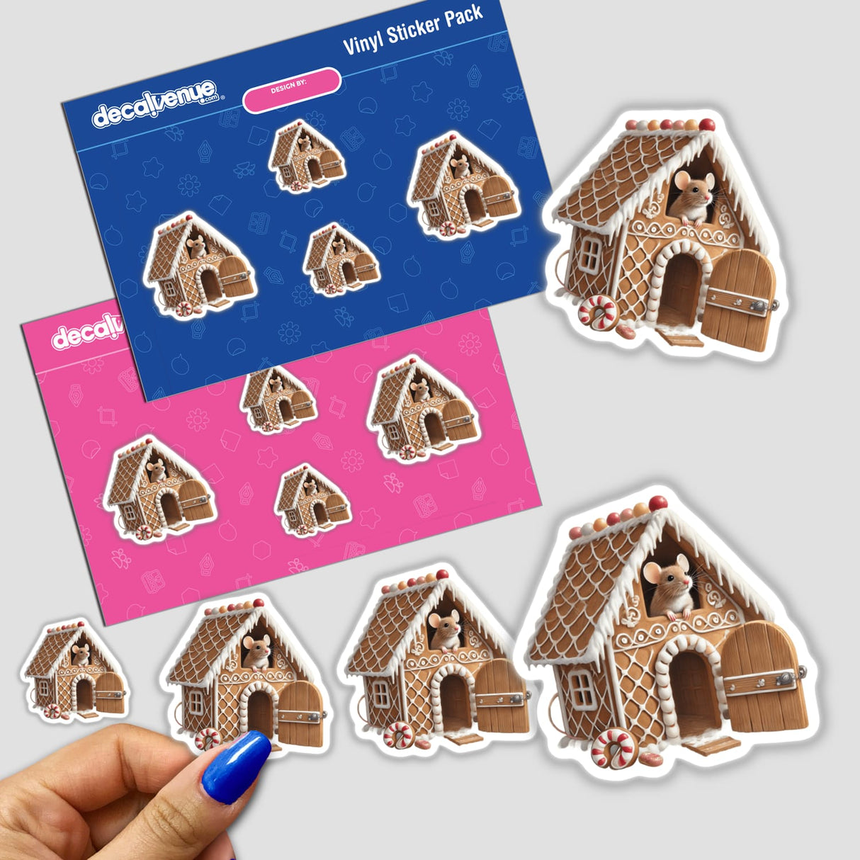 Mouse peeks out of a gingerbread house in a sticker pack, with a close-up of a hand holding one of the stickers.