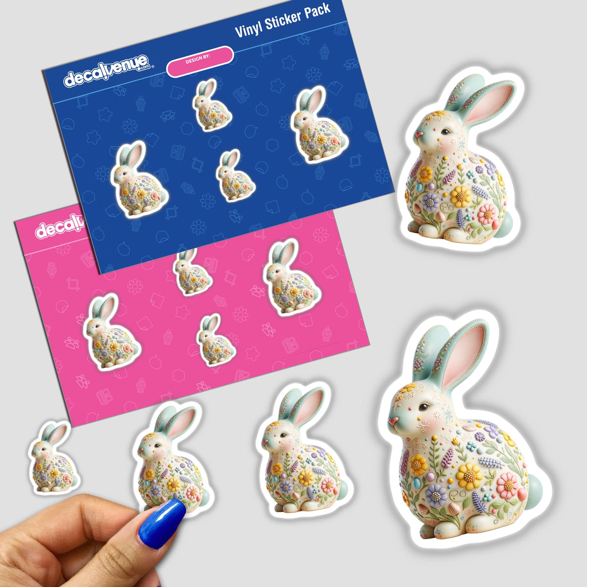 Hand-Painted Easter Bunny Figurine with Floral Design amidst sticker pack, featuring a whimsical bunny adorned with flowers, reflecting Decal Venue's unique vinyl stickers and digital art offerings.