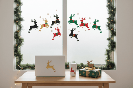 Festive christmas reindeer stickers decorate a window, laptop, and tumbler for holiday gift inspiration