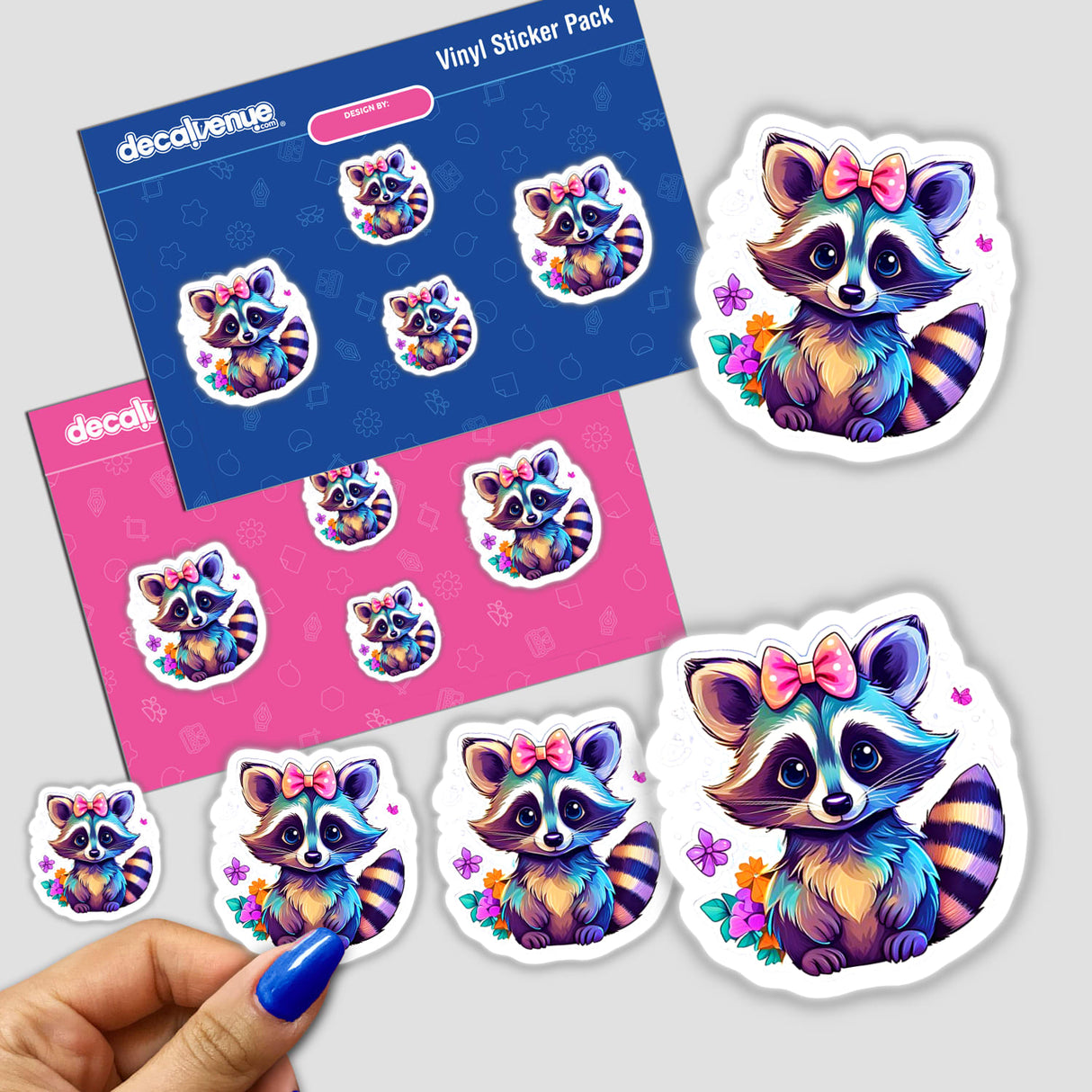 Baby raccoon stickers featuring a cartoon raccoon with a bow, shown in a person's hand. Available as stickers or digital artwork at Decal Venue.