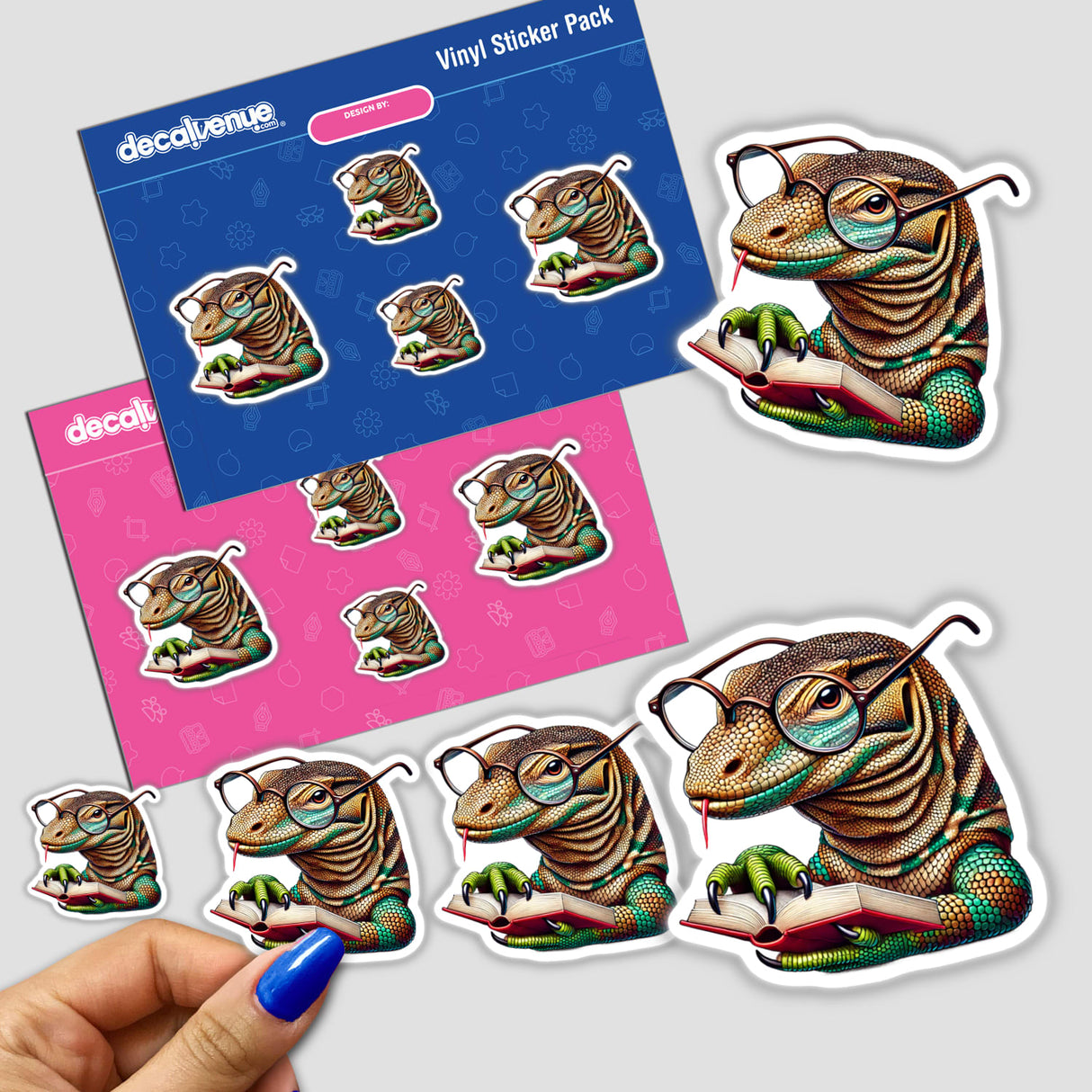 Komodo Dragon With Reading Glasses Open Book sticker, featuring a cartoon lizard wearing glasses and engrossed in reading, part of Decal Venue's unique vinyl stickers and digital art collection.