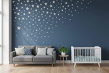 White Stars Vinyl Wall Decals embellish a deep blue wall in a modern living-room/nursery setup, adding a whimsical touch with their matte finish and customizable arrangement.