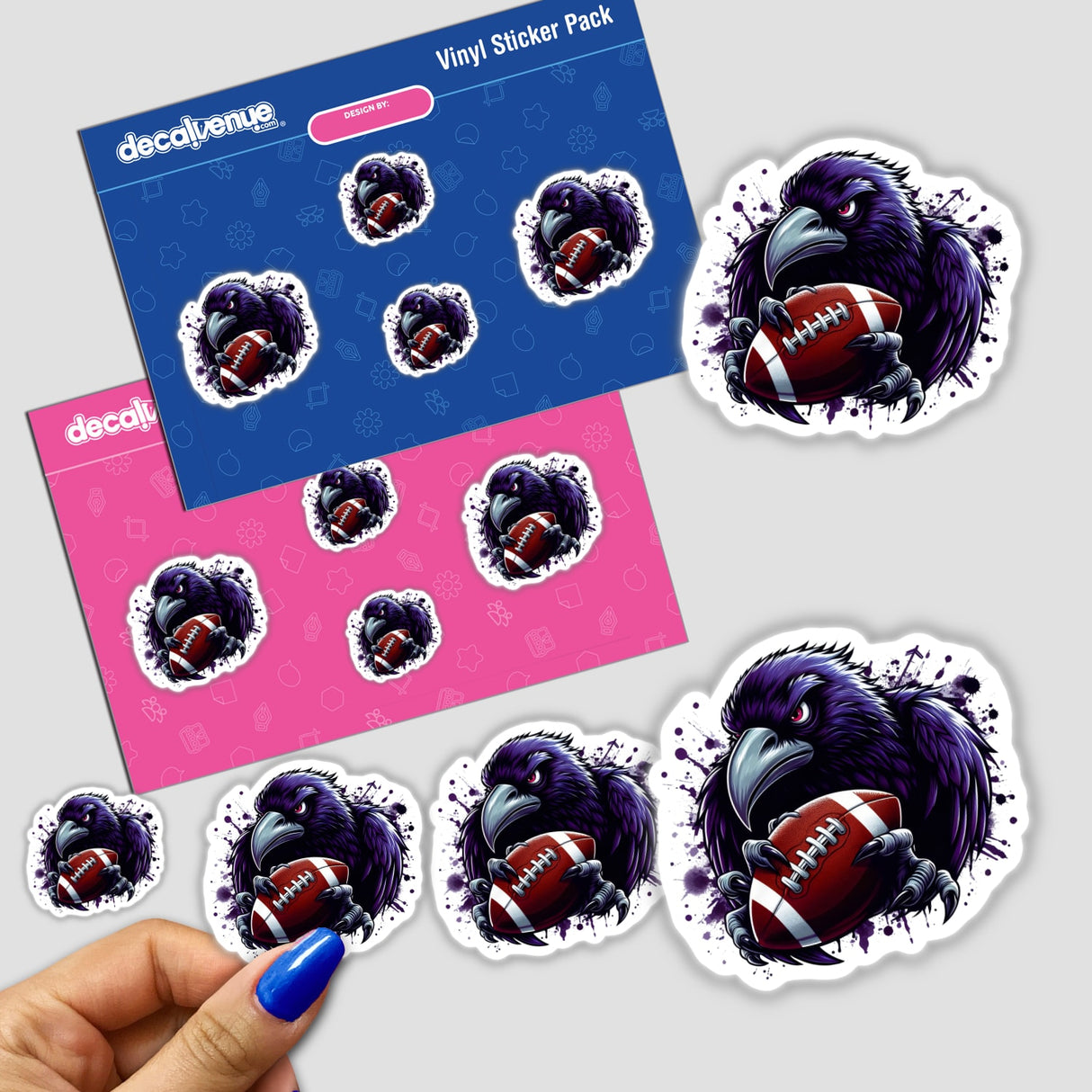 Angry Purple Ravens Football Bird vinyl sticker pack features a stylized raven clutching a football with ink-splatter accents. Displayed on blue and pink sheets, a hand peels one sticker.