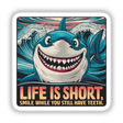Colorful digital artwork depicting a smiling shark against a background of ocean waves. The text overlay reads "LIFE IS SHORT. SMILE WHILE YOU STILL HAVE TEETH."