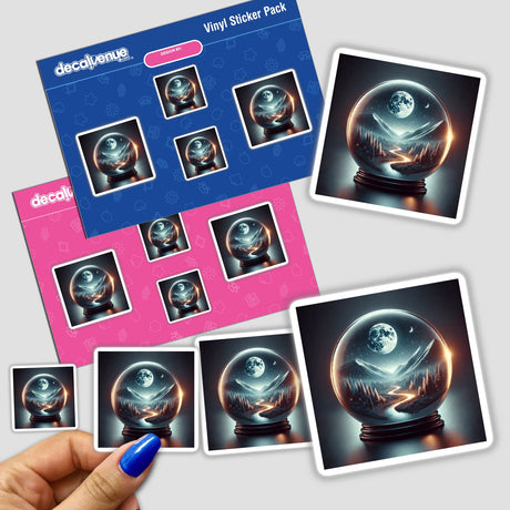 Hand holding a sticker pack featuring Starlit Path - Moonlit Road Winding Through a Globe with a snow globe showing a moon and mountains inside.