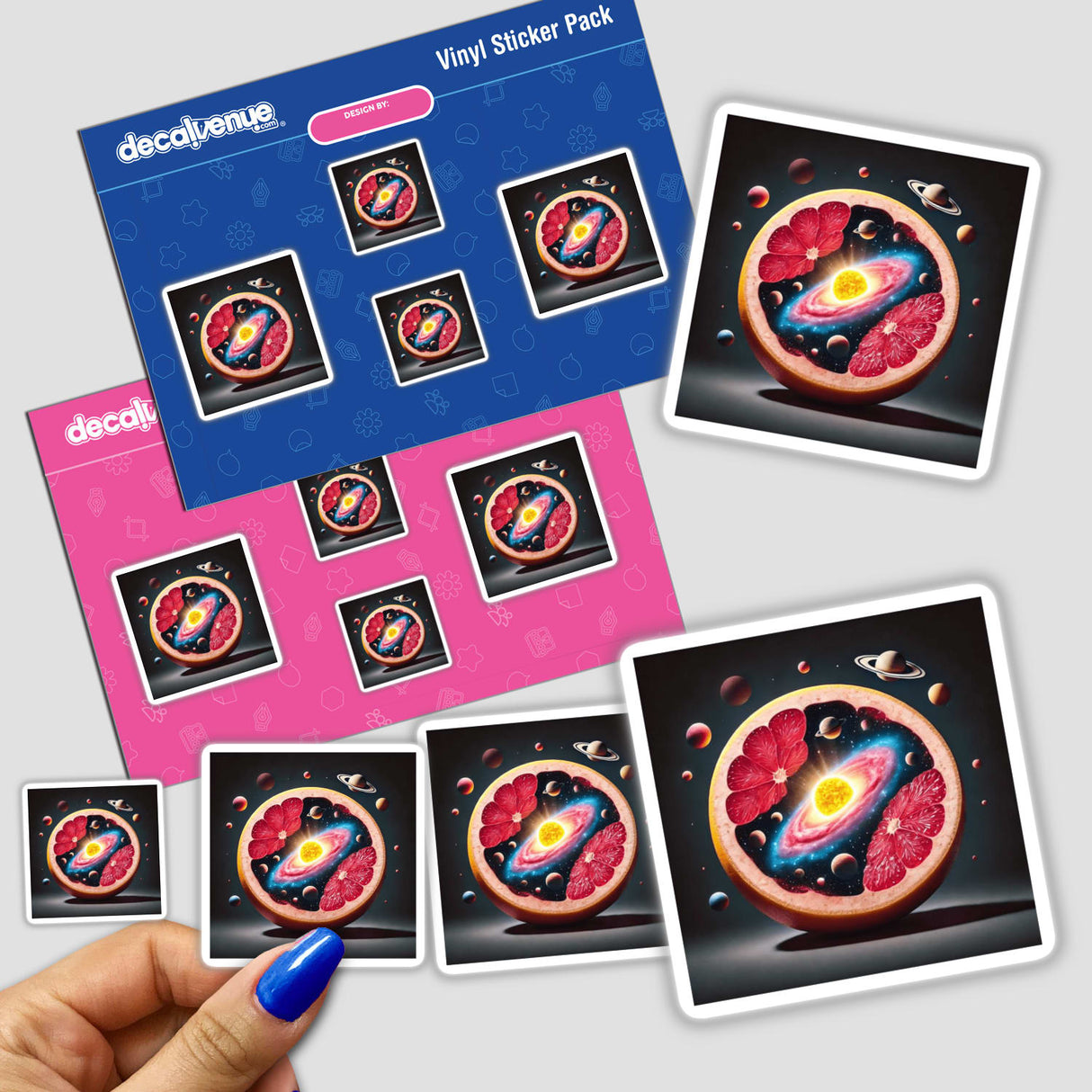 Hand holding stickers showing a Cosmic Citrus Solar System Inside a Grapefruit, with planets and stars integrated into the fruit's design. Available as stickers or digital artwork.