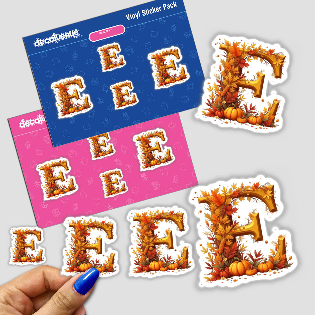 Hand holding Fall Aesthetic Letter E sticker with leaves and pumpkins, available as stickers or digital artwork, for commercial use from Decal Venue.
