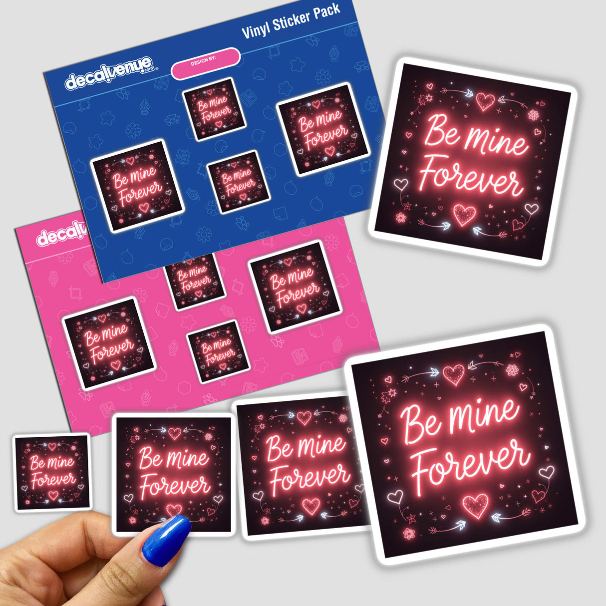 Be Mine Forever Valentine Glow Design sticker pack, held in hand, featuring pink and white square cards with text and heart motifs. Suitable for unique vinyl stickers or digital artwork.