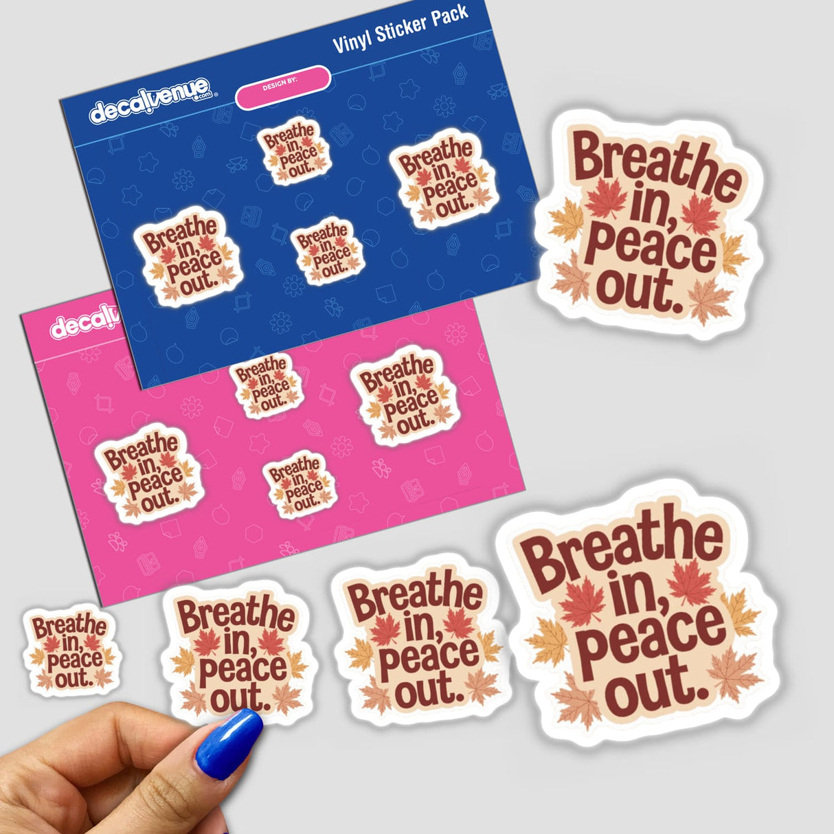 Hand holding the Breathe In Peace Out Positive Affirmation Sticker featuring text and leaves, available as a sticker or digital artwork for commercial use.