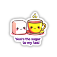 Cartoon illustration of a yellow tea cup and sugar cube with smiling faces, featuring the phrase You're The Sugar To My Tea for stickers or digital artwork from Decal Venue.