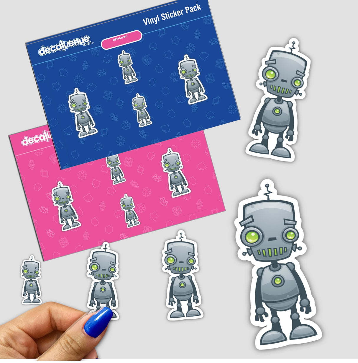 Silly Robot sticker pack featuring cartoon robots with green eyes, available as single stickers or in a pack. A hand holds one sticker, showcasing the playful design from Decal Venue.