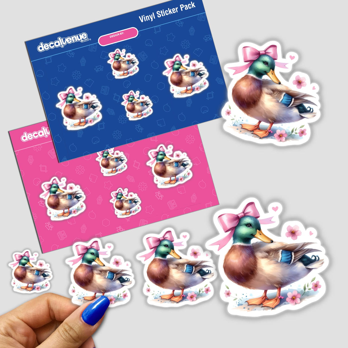 Hand holding a Halloween Pumpkin and Bat Coquette Bow sticker featuring a cartoon duck with a bow.