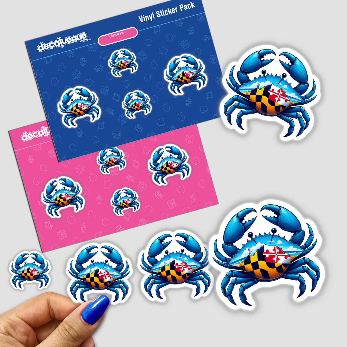 Maryland Blue Crab vinyl-sticker set from DecalVenue.com, showcasing the crab with a Maryland state-flag pattern. Multiple sizes appear on two backing cards, with three additional stickers, one held in hand.