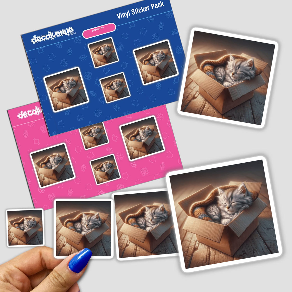 Kitten in Cozy Cardboard Box sticker depicting a cat comfortably sleeping inside a box, available as physical stickers or digital artwork.