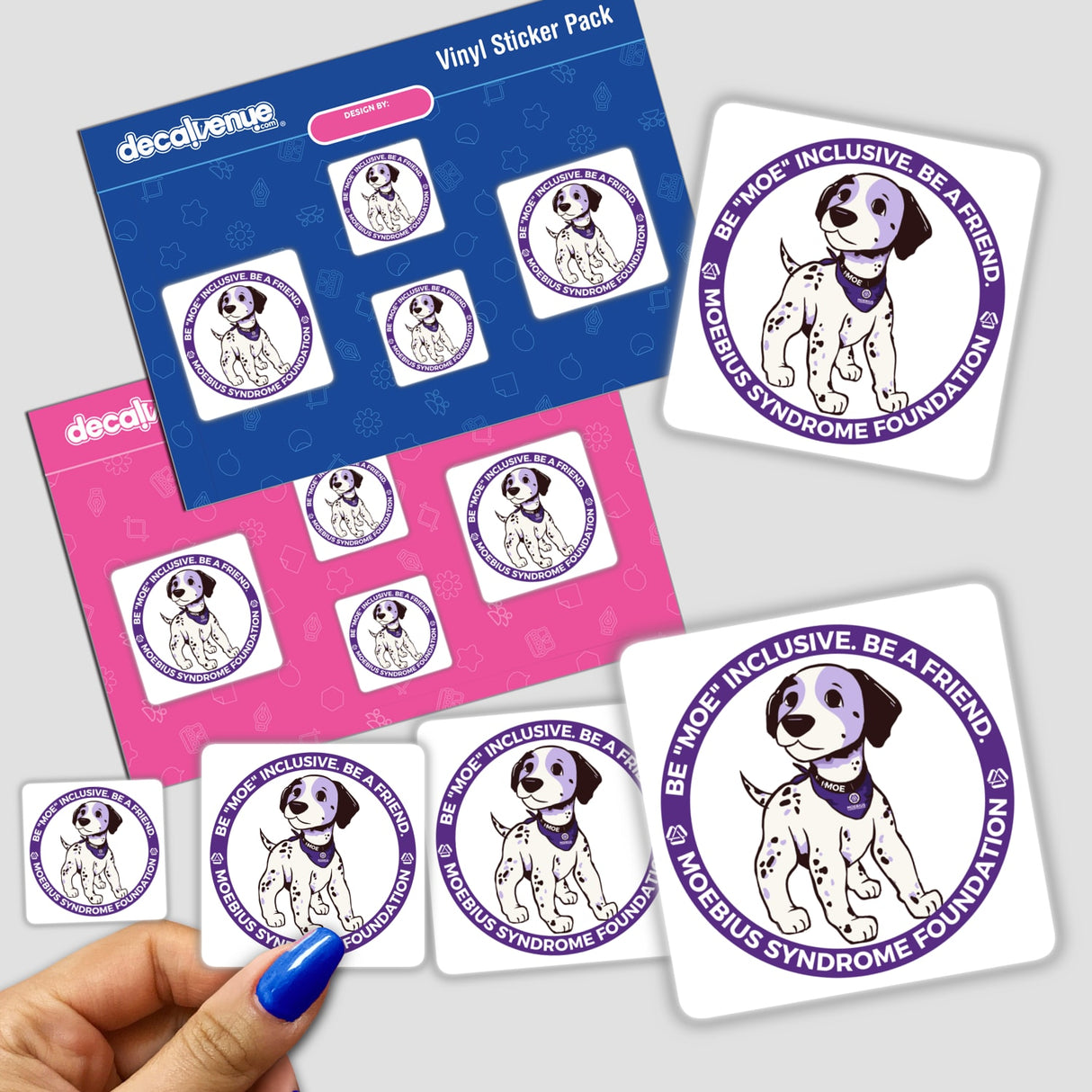 Hand holding “Be 'Moe' inclusive. Be a friend.” stickers featuring a cartoon dog with a purple bandana.