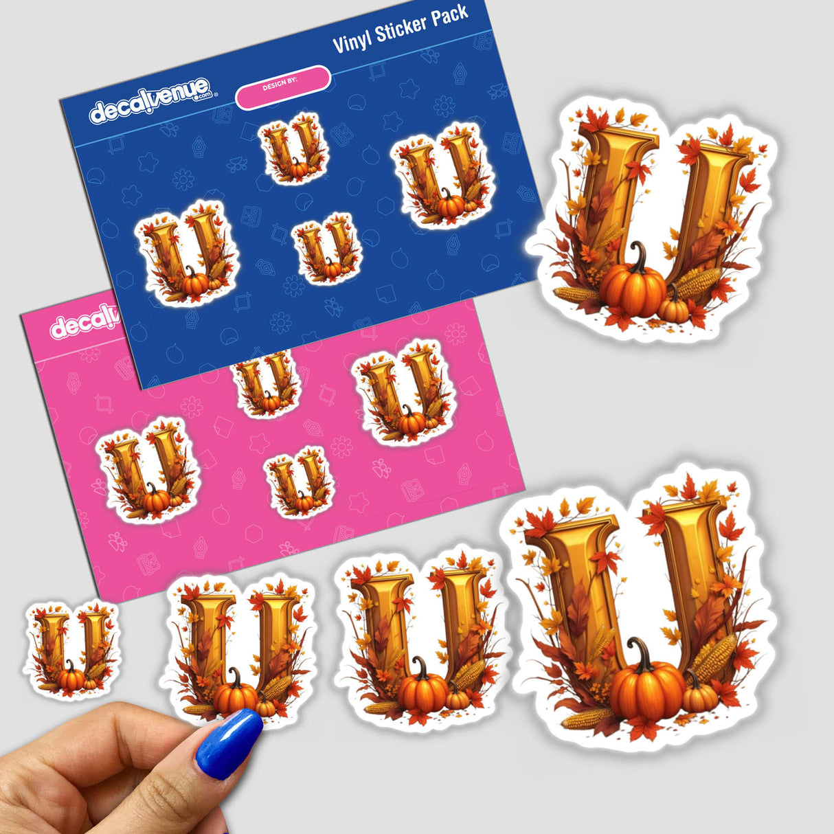 Hand holding a Fall Aesthetic Letter U Clipart sticker featuring pumpkins and leaves, available as stickers or digital artwork for commercial use.