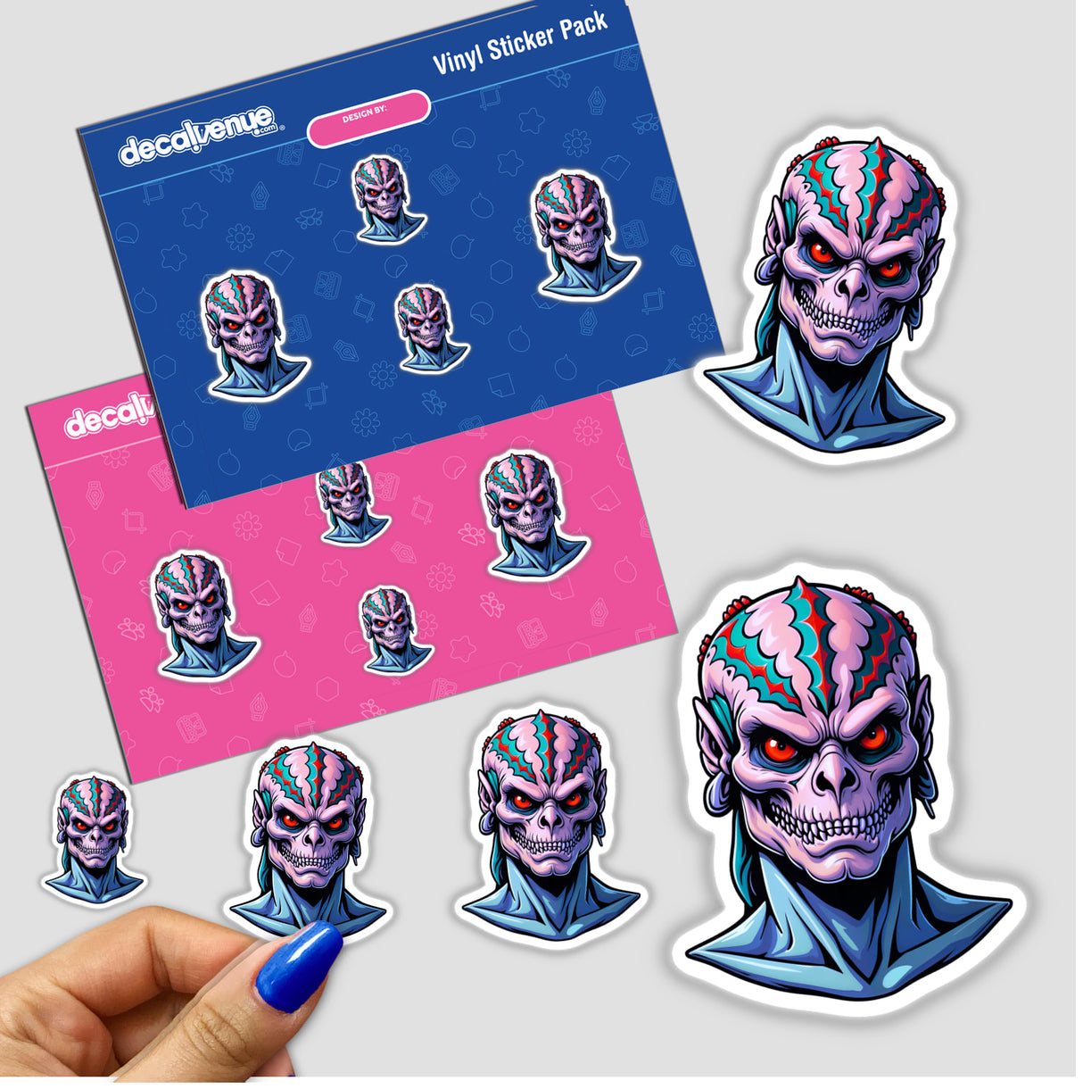 a hand holding a sticker with a picture of an alien head